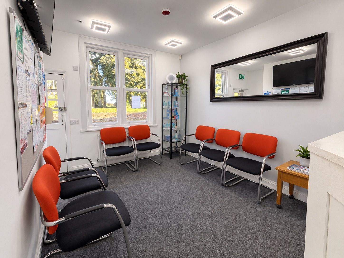 Bright waiting room with orange chairs at Toddington Dental Surgery